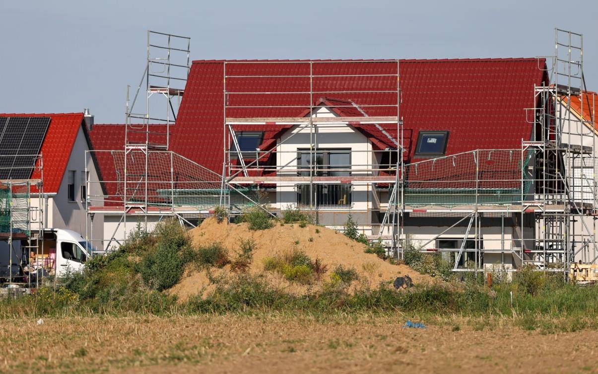 Neue Einfamilienhäuser entstehen an einem Feld am südwestlichen Stadtrand. Die Zahl der Baulandverkäufe ist Immobilienexperten zu Folge seit 2021 fast um die Hälfte zurückgegangen. Gestiegene Zinsen, hohe Baukosten und knappes Bauland haben den Traum vom Eigenheim stark verteuert.