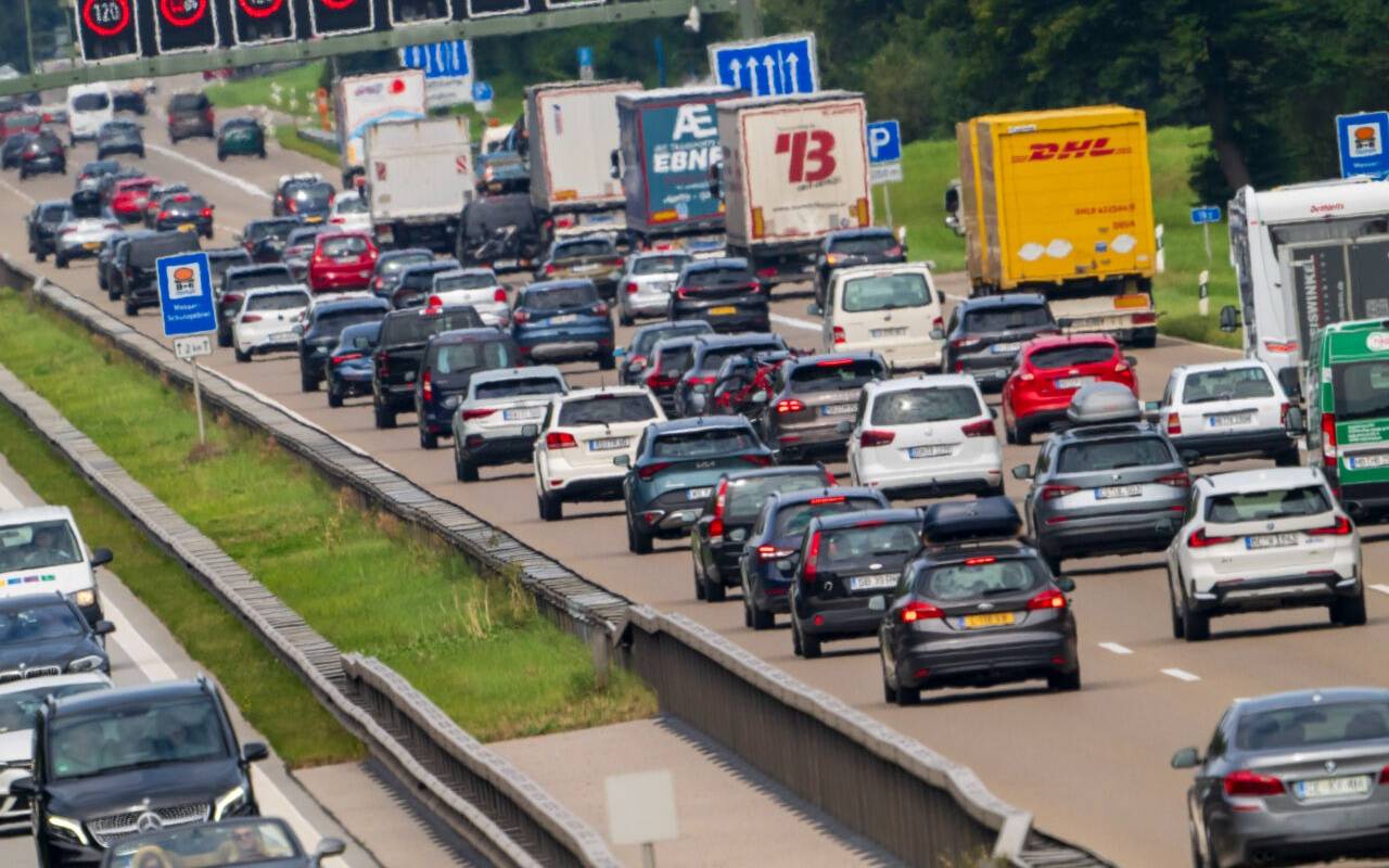PKW und LKW stauen sich während des Rückreiseverkehr auf der Autobahnen A8 bei Holzkirchen.