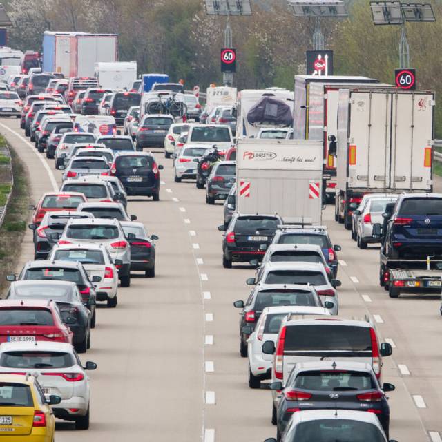Autos stehen auf der Autobahn im Stau. Grund dafür ist eine Baustelle.