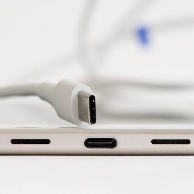 USB-C-Kabel und Ladebuchse an einem Smartphone