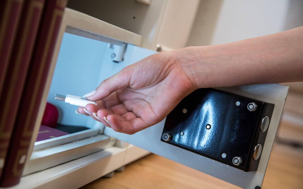 Eine Frau legt einen USB-Stick in einen Safe