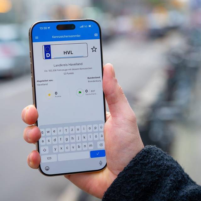 Ein Mann nutzt die App Kennzeichensammler auf einem Smartphone