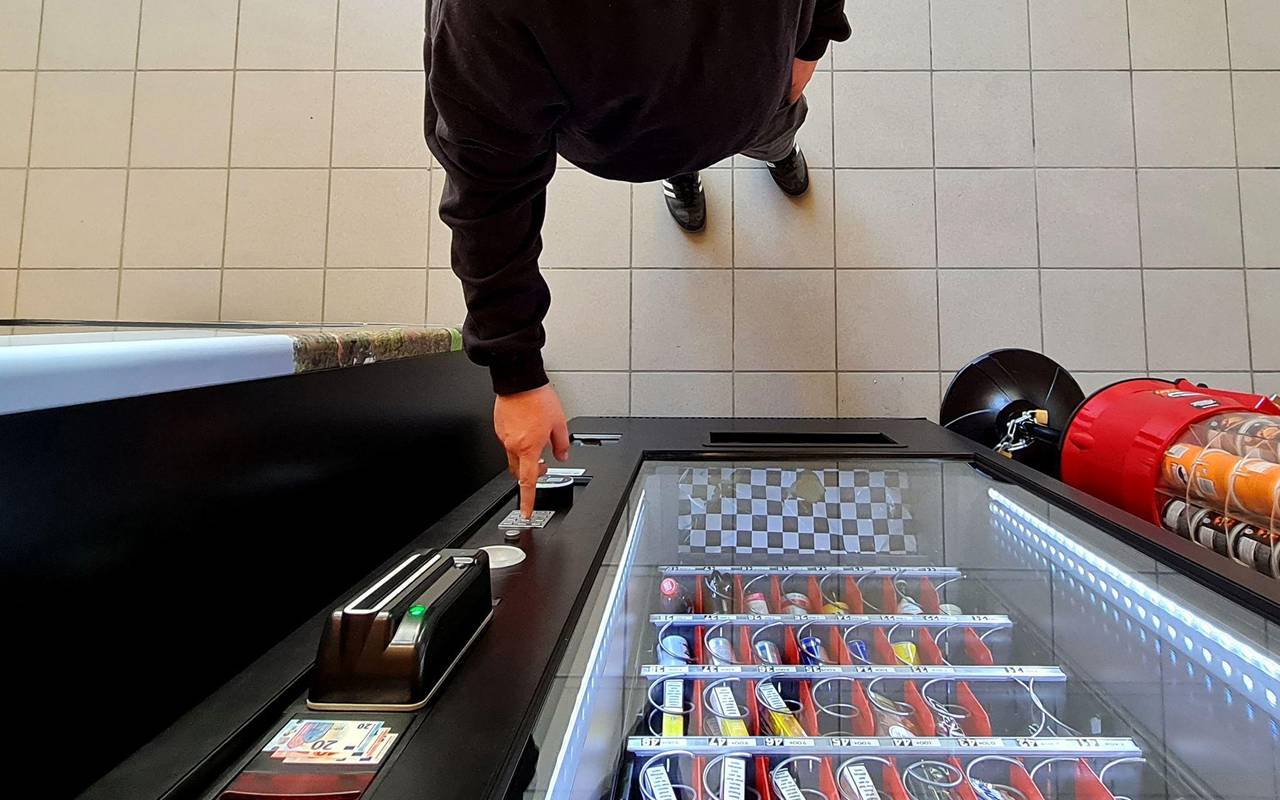 GEin Mann kauft etwas aus dem Automaten