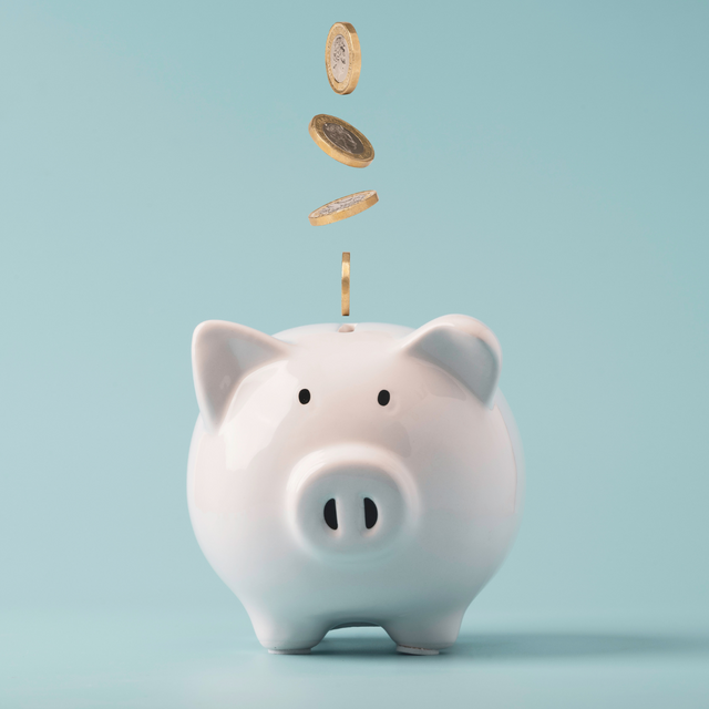 Minimalismus / weißes Sparschwein mit Kleingeld, hellblauer Hintergrund