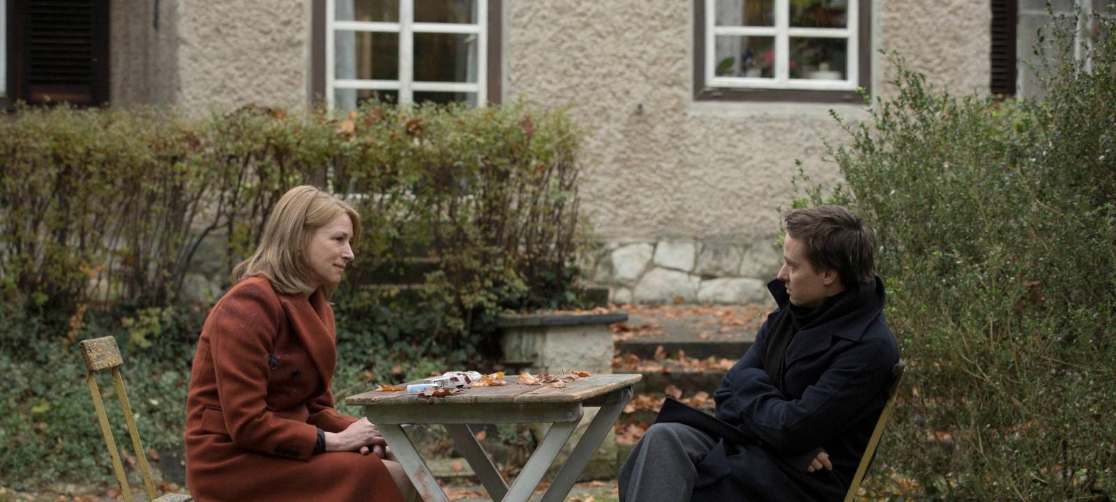 Lara sitzt mit ihrem Sohn im Garten.