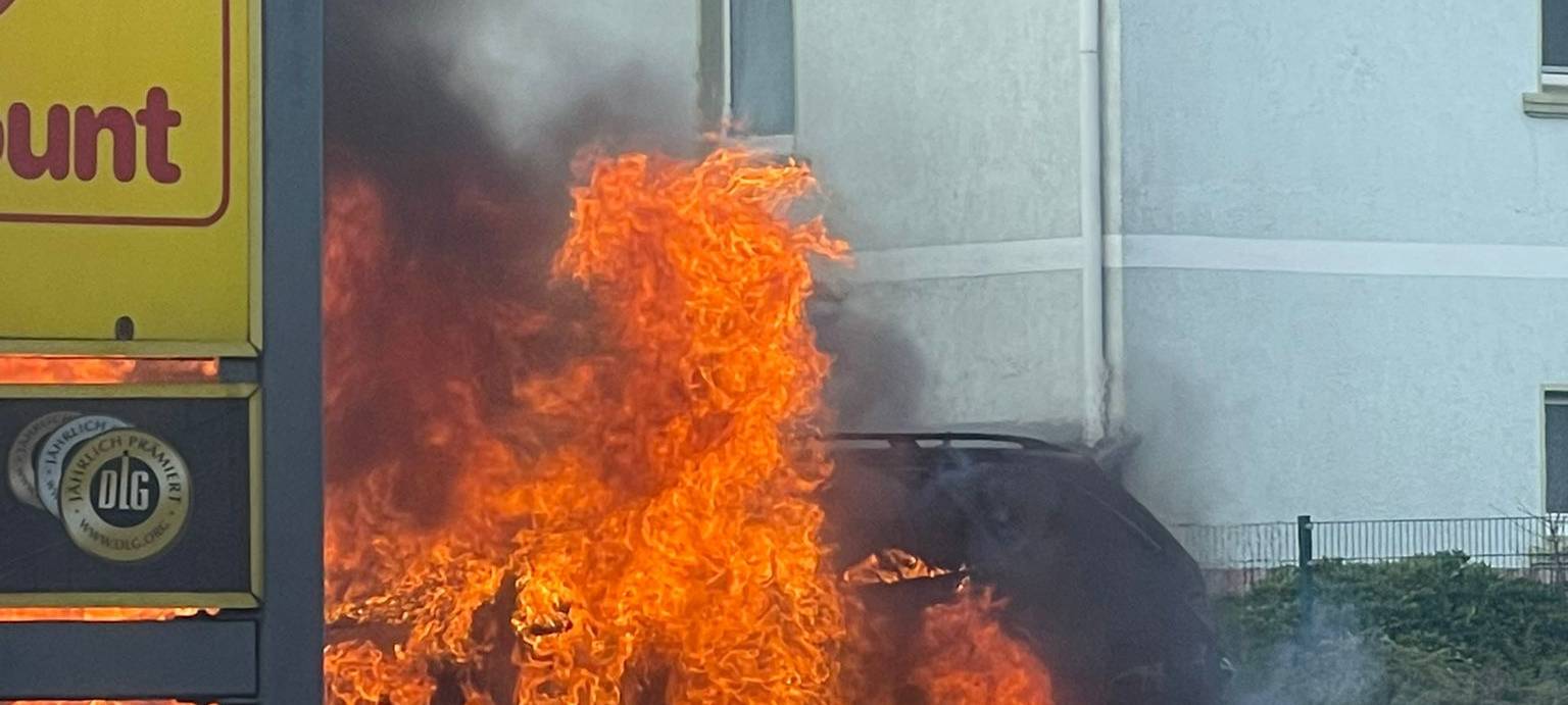 Autobrand auf Supermarktparkplatz