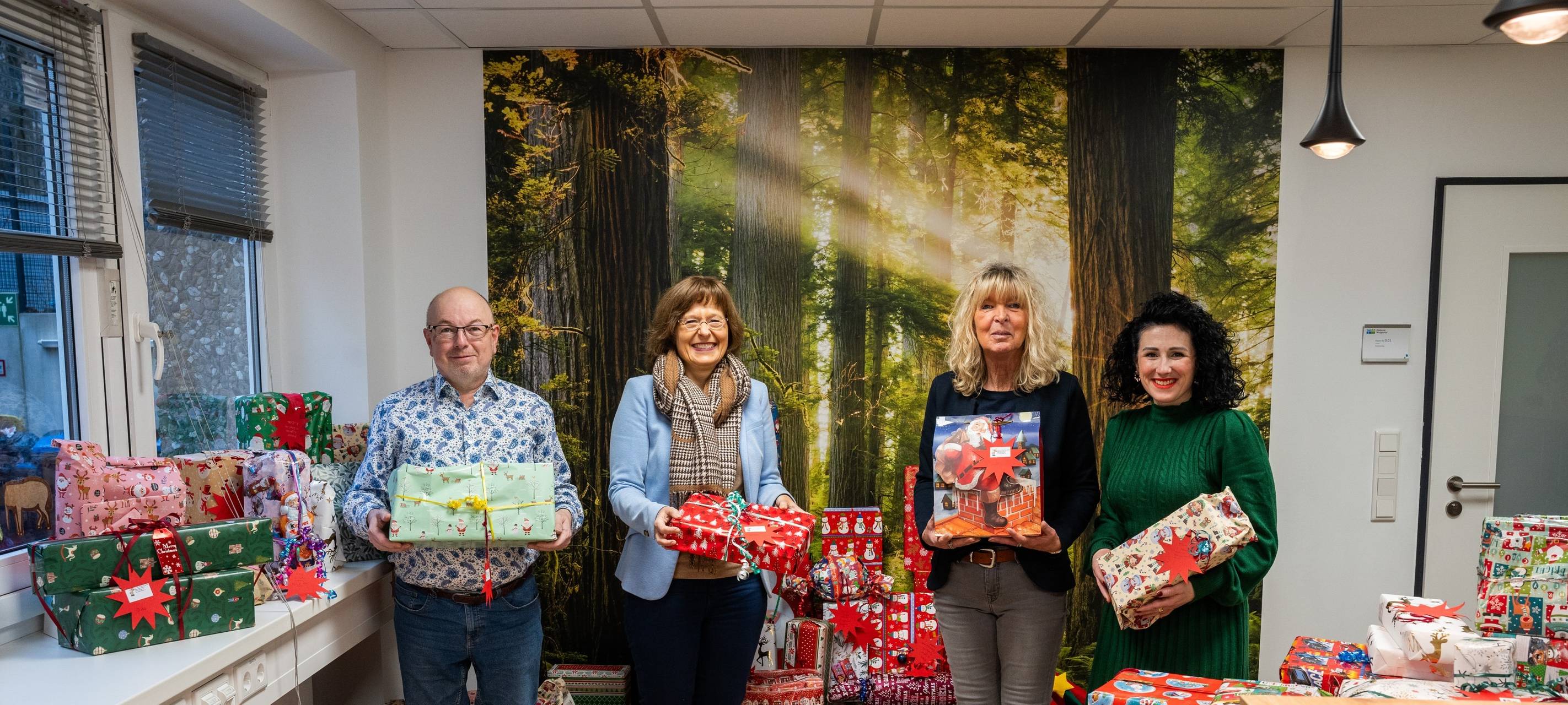 Mitarbeitende der Diakonie halten verpackte Weihnachtsgeschenke