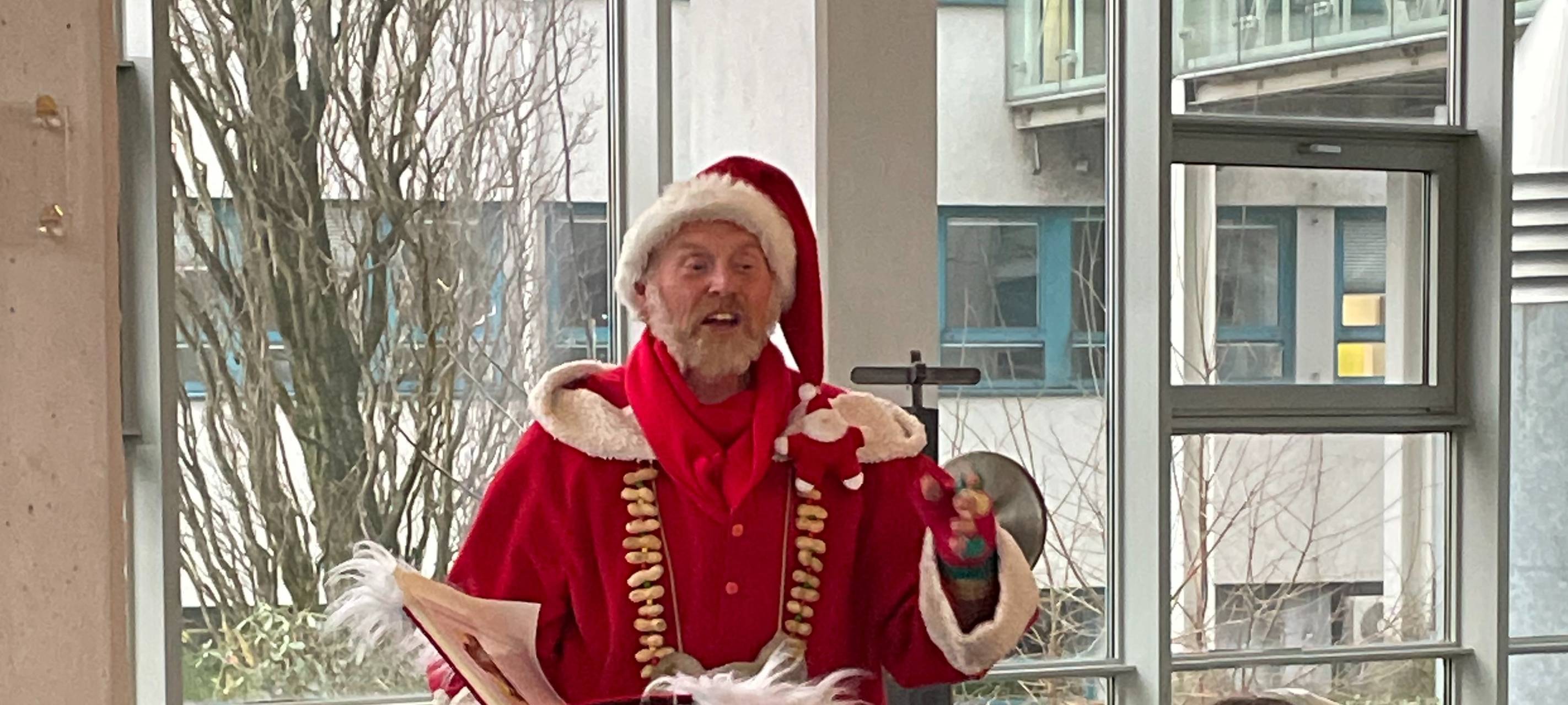 Ein als Weihnachtsmann verkleideter Mann vor Kindern