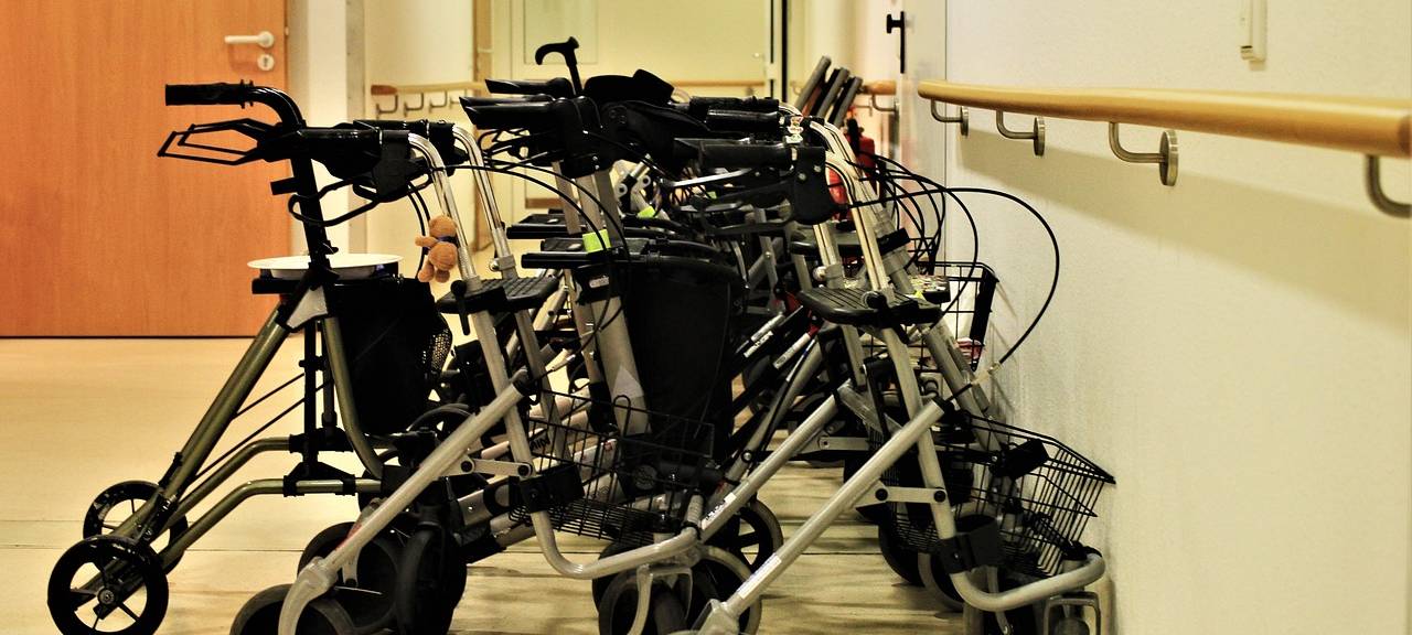 Mehrere Rollatoren stehen im Flur eines Altenheims