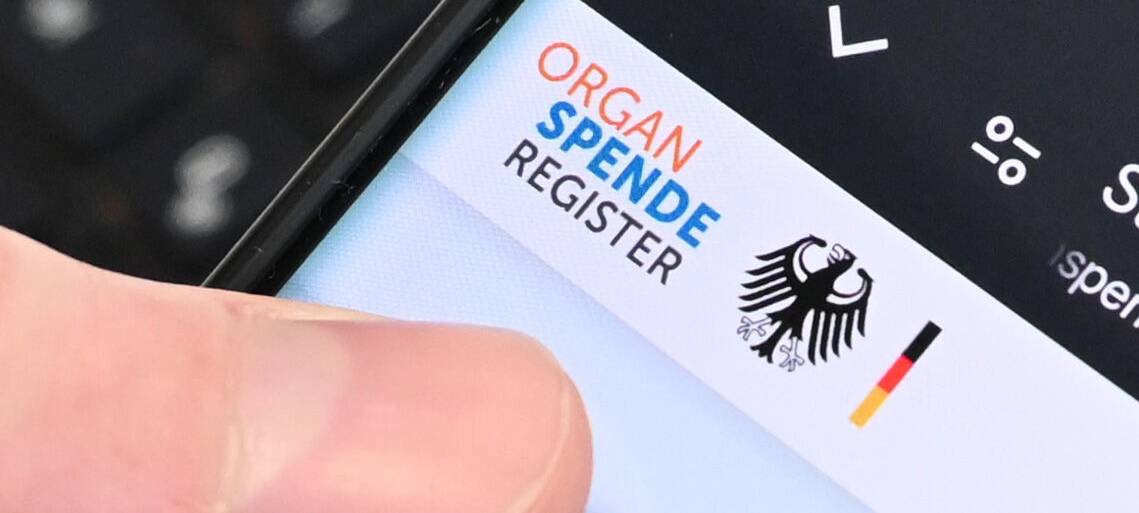 Eine Person hält ein Handy in der Hand, auf dem das Online-Portal zur Registrierung zur Organspende zu sehen ist.