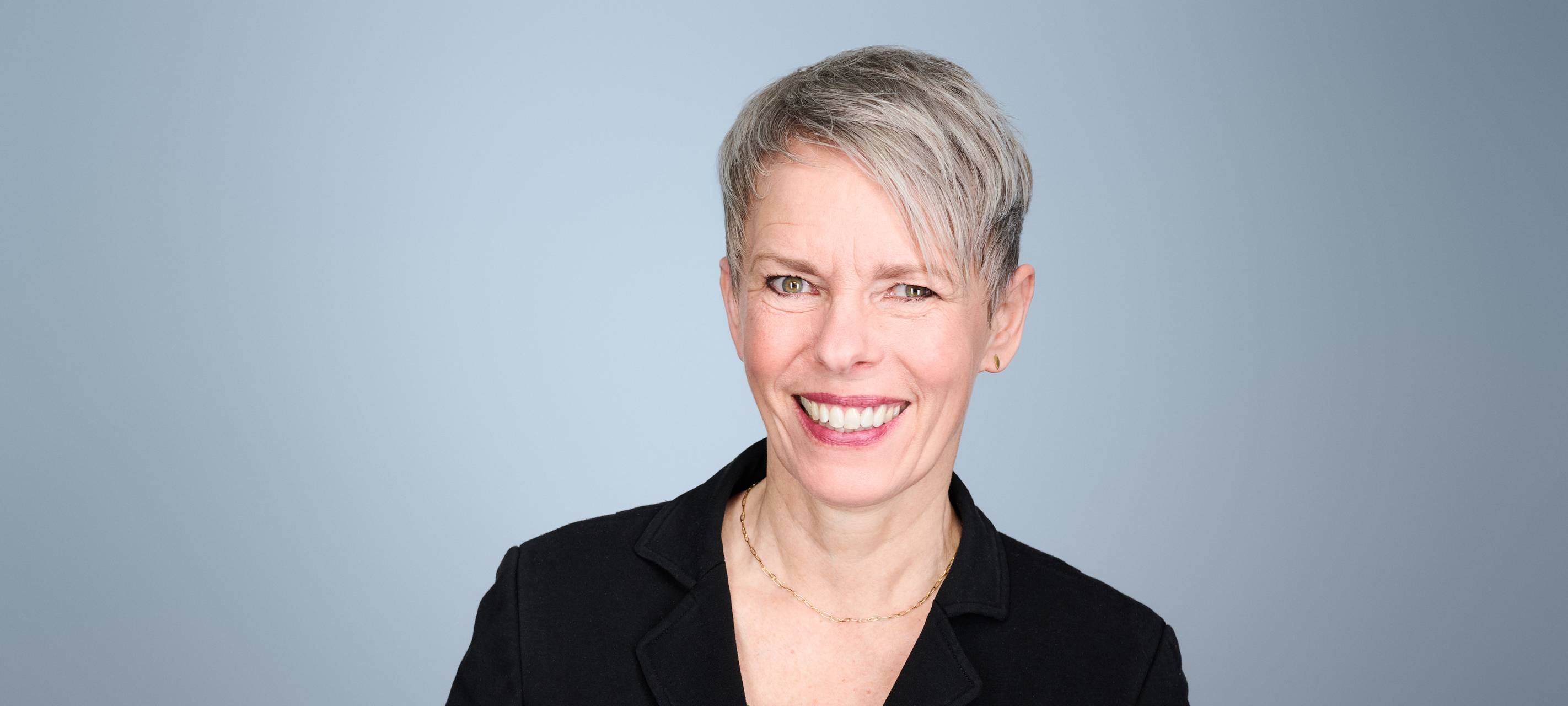 Die neue Geschäftsführerin der Wupperatler Bühnen, eine 57-jährige Frau mit kurzen grauen Haaren und vielen Zähnen