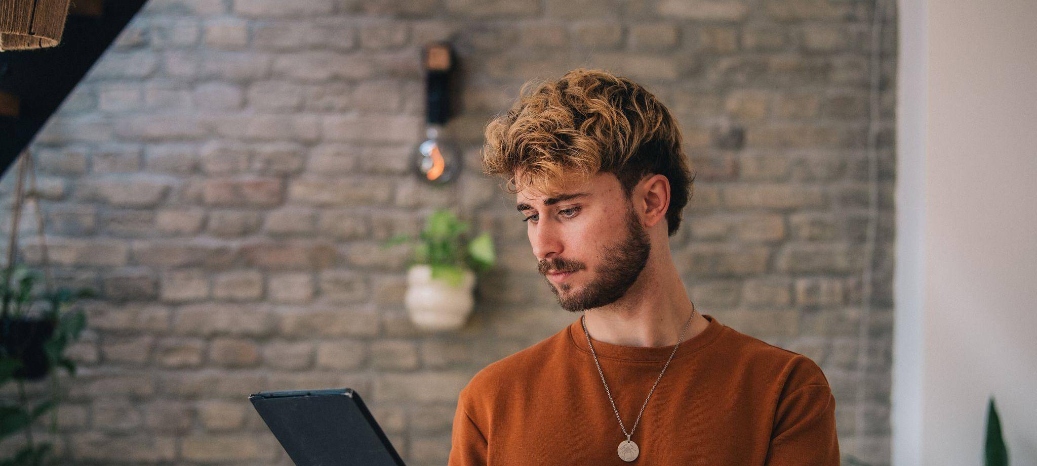 Ein Mann hält ein Tablet in den Händen
